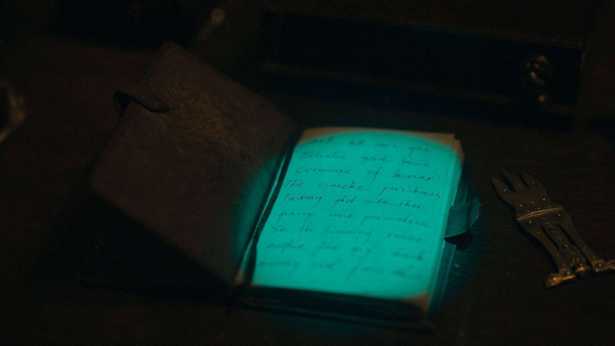 Alter Terminkalender auf dunklem Holz, eine Zeile leuchtet teal auf